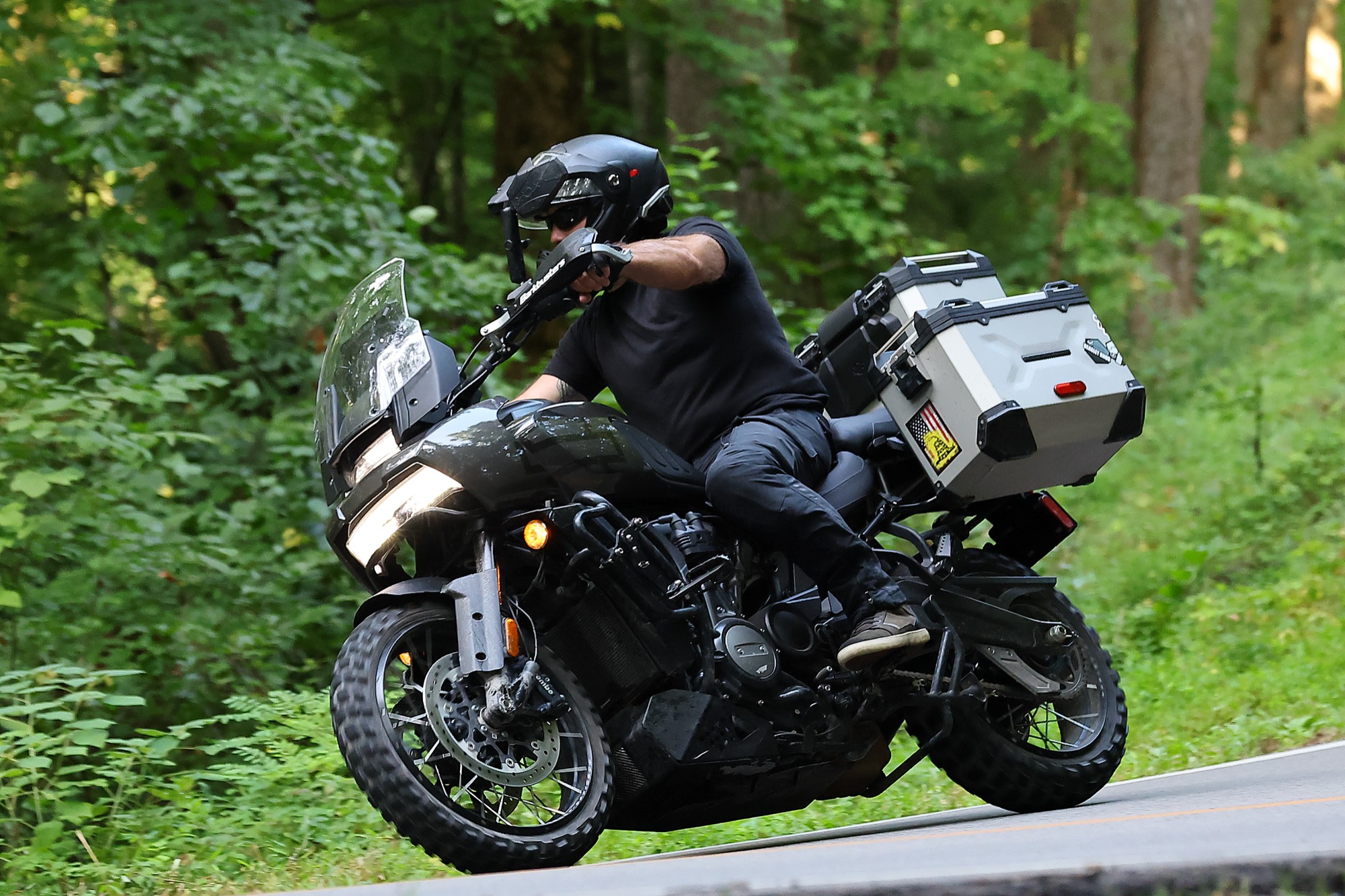 Jason Duncan leaning his Harley-Davidson Pan America into a wooded curve