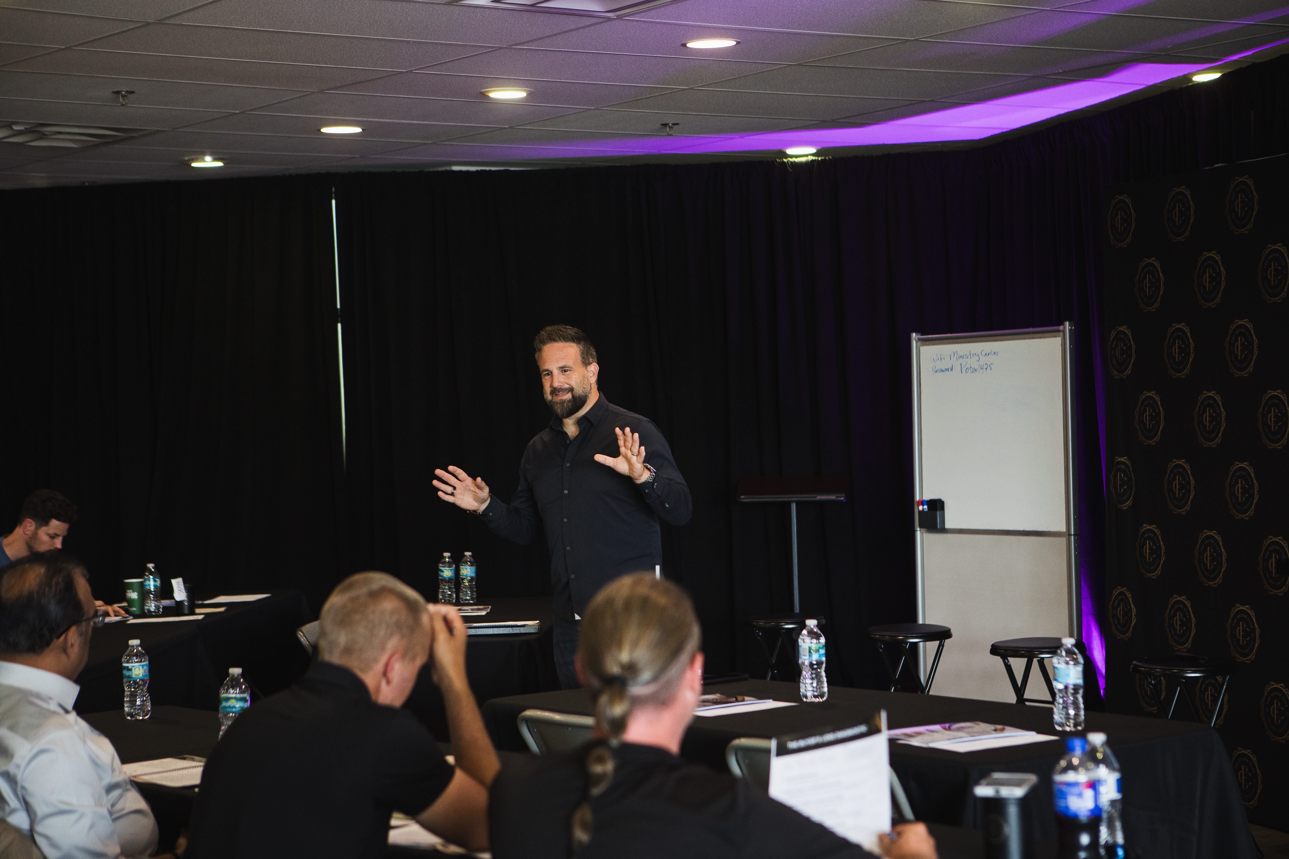 The Real Jason Duncan speaking at an event, standing and gesturing to the audience